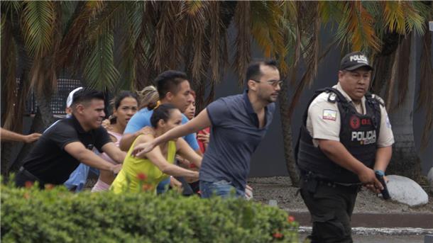 Die Polizei führt Mitarbeiter des Fernsehsenders TC in Guayaquil aus dem Gebäude.