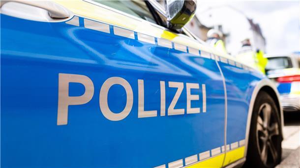 Zwei Einsatzfahrzeuge der Polizei stehen in Freiburg am Straßenrand.