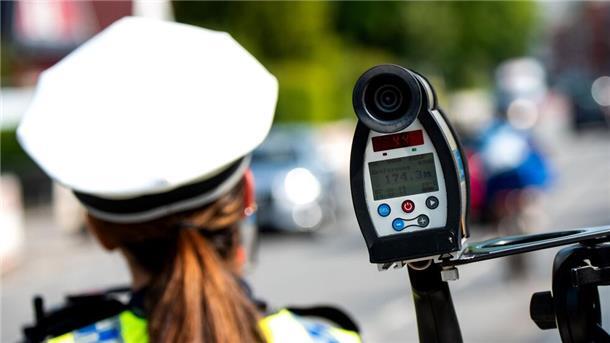 Tempo- und Abstandskontrollen: Polizei startet ROADPOL-Schwerpunkt Eine Polizistin misst mit einem Laser die Geschwindigkeit eines Autos
