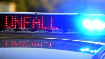 Auf einem Polizeifahrzeug warnt eine Leuchtschrift vor einer Unfallstelle. 
