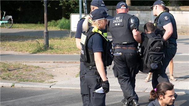 Die Polizei trägt einen Aktivisten der Gruppe Letzte Generation weg, der mit anderen die Fahrbahnen rund um die Siegessäule in Berlin blockiert hat.