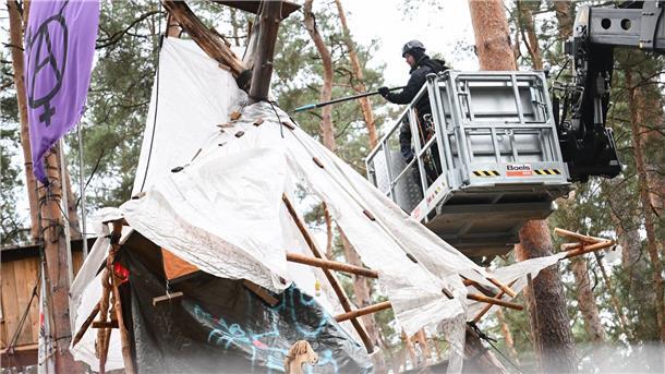 Die Polizei überprüft die Bauten der Tesla-Gegner in Wald in Grünheide. Die Umweltaktivisten müssen ihr Camp nach fast neun Monaten endgültig räumen.