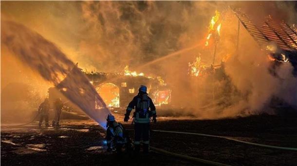 Feuerwehrmann vor einem brennenden Haus.  