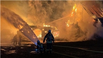 Feuerwehrmann vor einem brennenden Haus.  