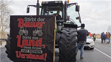 Traktor mit Plakat vor der Motorhaube