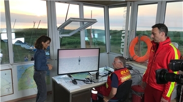 Die RTL-Moderatorin Nazan Eckes bespricht sich im DLRG-Wachturm in Sahlenburg mit Dieter Sandforth (Mitte, Vorsitzender des Ortsverbandes Cuxhaven) und Christoph Plaisier, Pressesprecher der DLRG Cuxhaven.