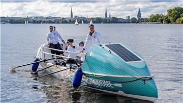 Ein Ruderboot mit vier Frauen auf einem See.