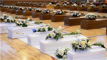 Die Särge der Opfer des Bootsunglücks stehen mit Blumen bedeckt in einer Sporthalle in Crotone.