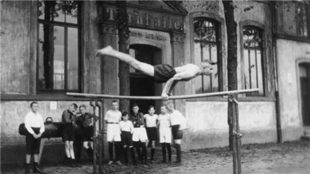 Louis Kleinschmitt turnt 1924 vor der Turnhalle des Geestemünder Turnvereins am Holzhafen.  