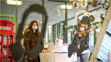 Die Schülerinnen Julienne Kebernik (l.) und Ingrid Gorbunov betrachten eine Spiegel-Skulptur mit den Silhouetten einer jungen und einer alten Sophie Scholl. Das Kunstwerk steht im Schulzentrum Geschwister Scholl in Bremerhaven.