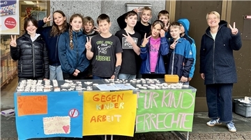 Gruppe von Kindern mit ihrer Lehrerin an einem Stand. Sechstklässler des Nordenhamer Gymnasiums sammelten in der Innenstadt für UNICEF.