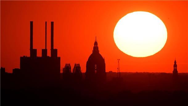 Kühle Orte und Wasserspender: Was Städte gegen Hitze tun Die Sonne geht hinter dem Gaskraftwerk Linden und dem Neuen Rathaus unter.
