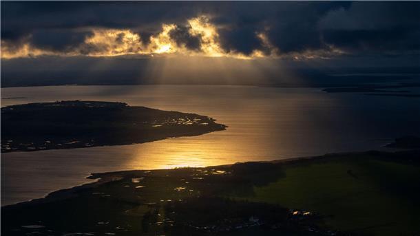 Bilder des Tages Die Sonne geht hinter Wolken über der Insel Rügen unter.