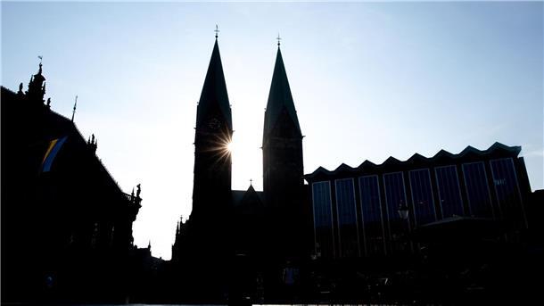 Neue Verfassung für Bremische Evangelische Kirche Die Sonne scheint hinter den Türmen des Sankt-Petri-Doms am Bremer Marktplatz.