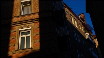 Die Sonne scheint zwischen zwei Häusern auf Fenster von Wohnungen.