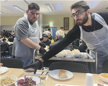 Männer servieren Essen in einem Saal
