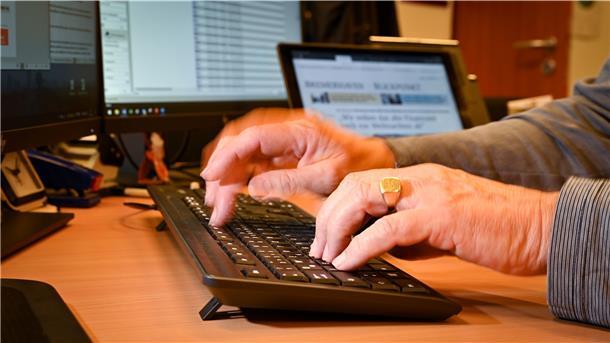 Hände tippen auf eine Computertastatur.