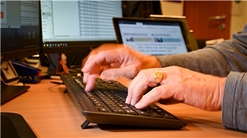 Hände tippen auf eine Computertastatur.
