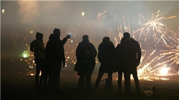 Eine Gruppe von Menschen schaut bei einem Feuerwerk zu.