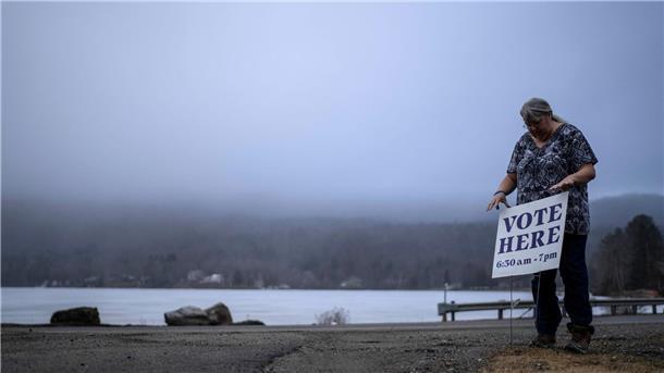 „Super Tuesday“: US-Vorwahlen in vielen Bundesstaaten Die Stadtschreiberin Sandra Lacasse platziert ein Wahl-Schild vor dem Stadtbüro in Elmore (Vermont).
