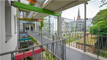 Eine Brücke verbindet Häusereingänge-