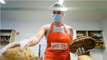 Steffi, ehrenamtliche Helferin bei der Potsdamer Tafel, stapelt vor Beginn der Ausgabe an Bedürftige Brot aus Supermärkten nach Sorten. 