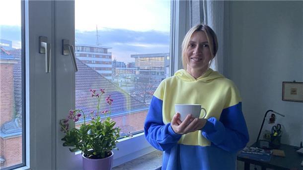 Eine Frau steht vor einem Fenster. 