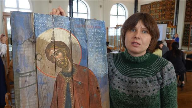 Kiewer Künstler malen Ikonen auf alte Munitionskisten Die ukrainische Künstlerin Sonja Atlantowa steht neben einer modernen Ikone im Museum für angewandte Kunst in Kiew.