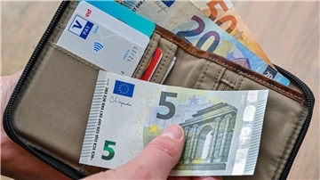 Eine Frau hält Geldscheine in der Hand.