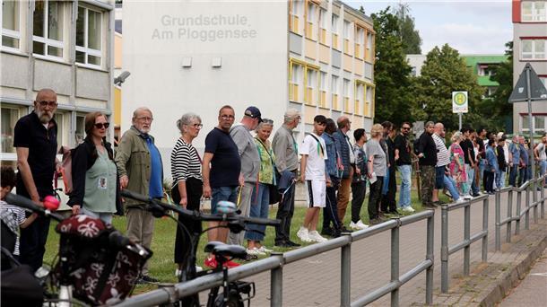 Die Veranstalter sprachen von rund 500 Teilnehmern, die sich mit bunten Bändern zu einer Kette verbunden hatten.