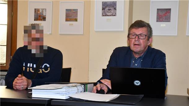 Zwei Männer sitzen am Tisch. 