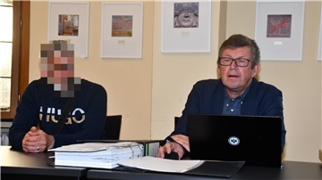 Zwei Männer sitzen am Tisch. 