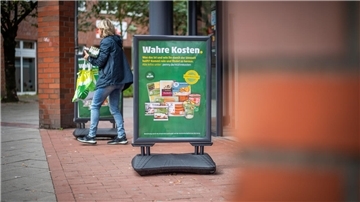 Werbeaktion des Lebensmittel-Discounters Penny an der Hafenstraße zu Produkten mit "Wahren Kosten".