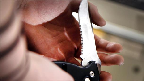 Klinge eines Klappmessers in einer Hand.