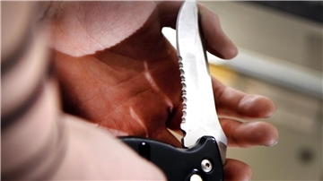 Klinge eines Klappmessers in einer Hand.