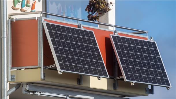 Solarmodule für ein sogenanntes Balkonkraftwerk hängen an einem Balkon.