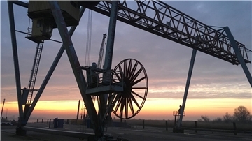 Laufkran im Großensieler Hafen im Licht der aufgehenden Sonne.