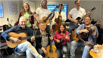 Eine Gruppe mit Gitarren und Ukulele: Die Zevener Gitarrenwoche bietet auch diesmal einen Workshop an.