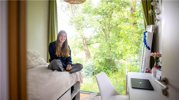 Neben der Schule in Mini-Häusern wohnen Die Zimmer sind klein, aber es gibt große Fenster.