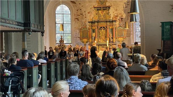 Kinder sitzen in einer Kirche.