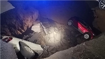 Die zwei geparkten Autos liegen in dem Erdloch.