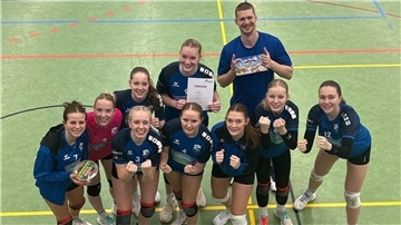 Eine Gruppe von jungen Frauen in Sportkleidung und ein junger Mann lächeln in die Kamera. 