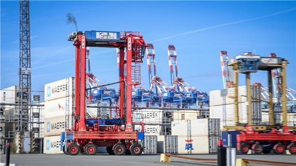 Stelzenfahrzeug vor Containern. 