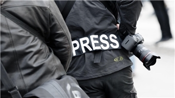 Dieser Reporter hat sich ein Schild umgehängt, damit er gut zu erkennen ist.