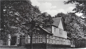 Dieses Foto aus dem Bestand von Helga Hink nimmt den Betrachter mit in die Zeit, als die Scheeßeler Straße in Sittensen von Bäumen gesäumt war. Es zeigt die ortsbildprägende Fassade des ehemaligen Gasthauses Kaiser, die bis heute nahezu unverändert blieb.