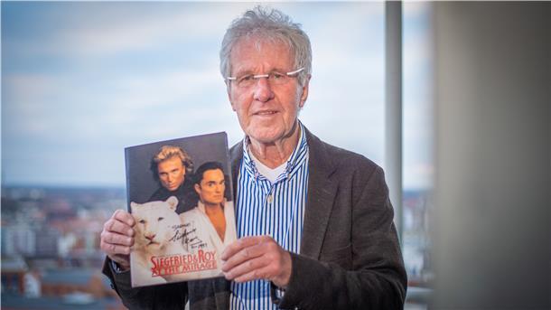 Dieter Bücking hält ein Erinnerungsstück an Siegfried und Roy in die Kamera: ein Magazin mit einer persönlichen Widmung der Weltstars.