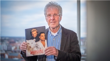 Dieter Bücking hält ein Erinnerungsstück an Siegfried und Roy in die Kamera: ein Magazin mit einer persönlichen Widmung der Weltstars.