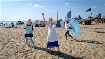Frauen tanzen am Strand in Bremerhaven.