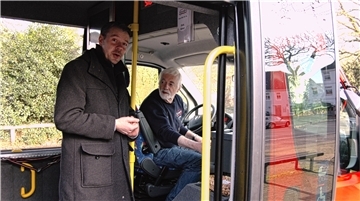 Zwei Menschen in einem Bürgerbus