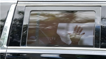 Donald Trump winkt auf dem Weg zum Gericht aus dem Fenster seiner Limousine.